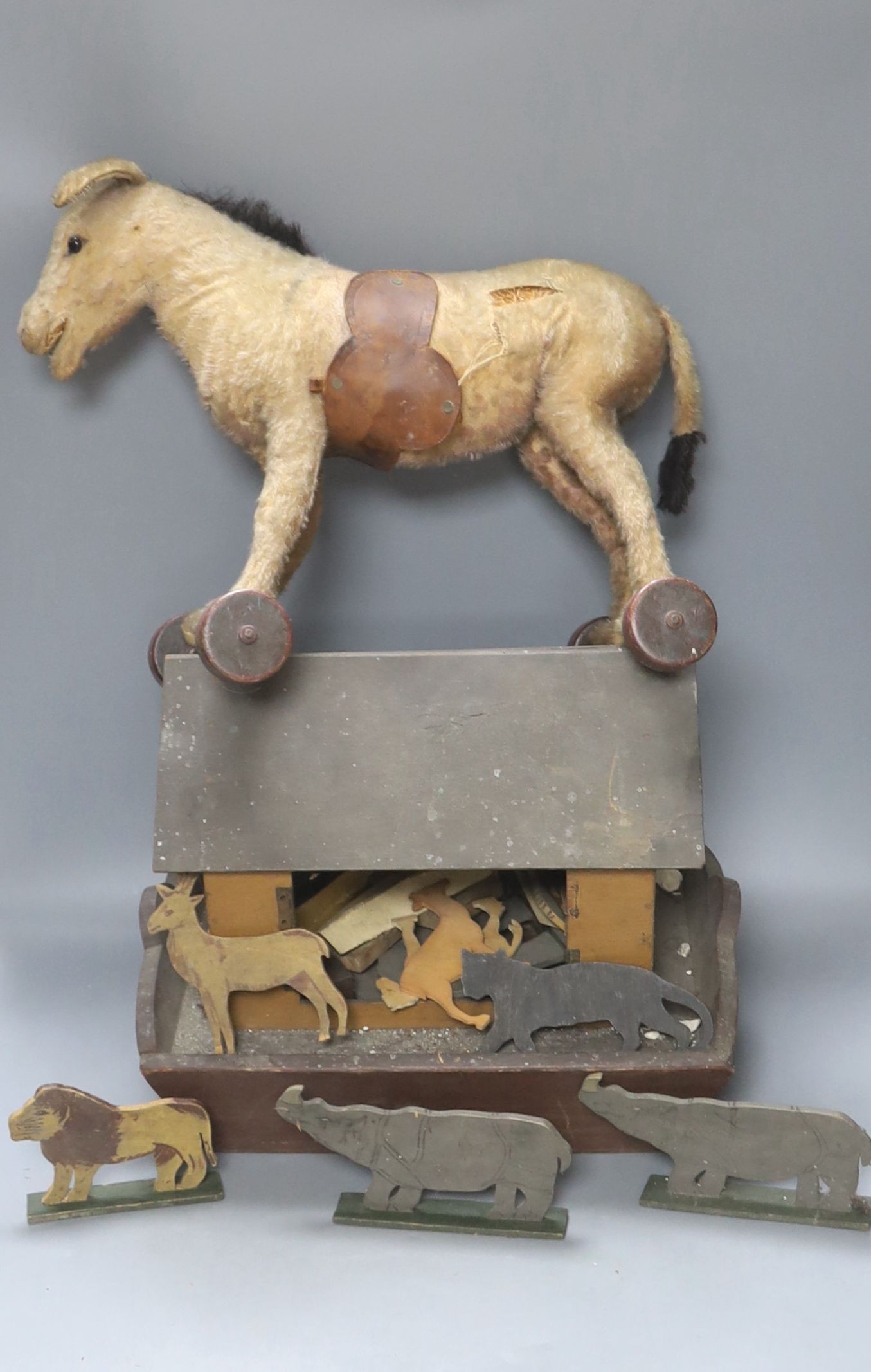 An early 20th century Steiff pull-along horse on wheels, boot button eyes and wood wool filling, button in left ear, 40cm long and a late 19th century painted plywood Noah's Ark with animals